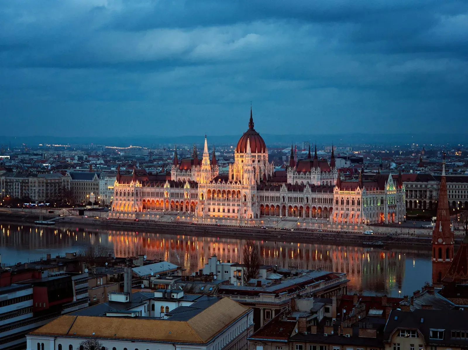 Hungarian Parliament Building lit up at dusk on the Danube